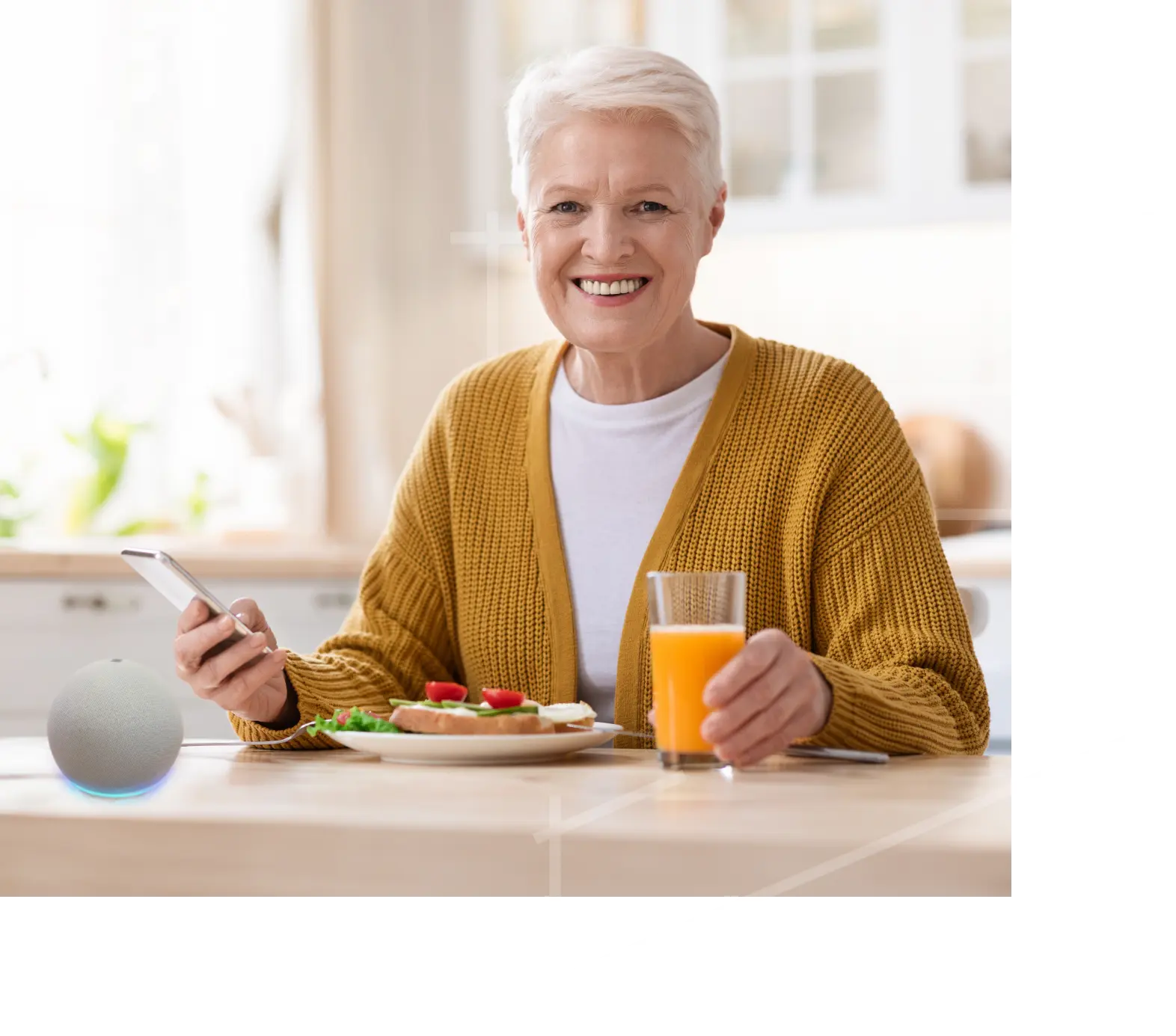 Woman sitting at table enjoying breakfast and controlling lights with her Alexa device. After receiving EA's home services